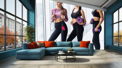 Group of three fit women with sport equipment are working out in gym. Wall mural